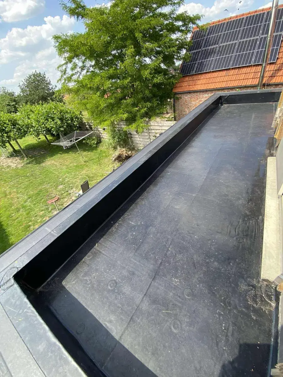 Nieuwe EPDM-folie wordt verlijmd op het platte dak